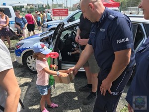 policjant częstuje dzieci słodkościami