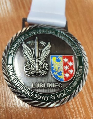 Zdjęcie przedstawia medal ze sportowych zawodów.