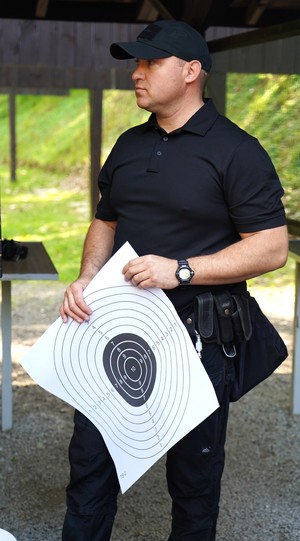Instruktor strzelania trzyma tarczę strzelecką