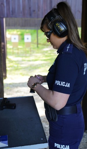 Policjantka ładuje broń.