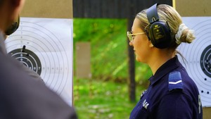 Policjantka stoi przy osi strzeleckiej,