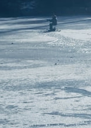 zdjęcie: zamarznięty staw i wędkarz na nim przebywający